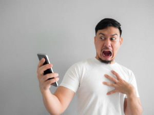 Shocked and scary face of man get yelled from smartphone.  See s
